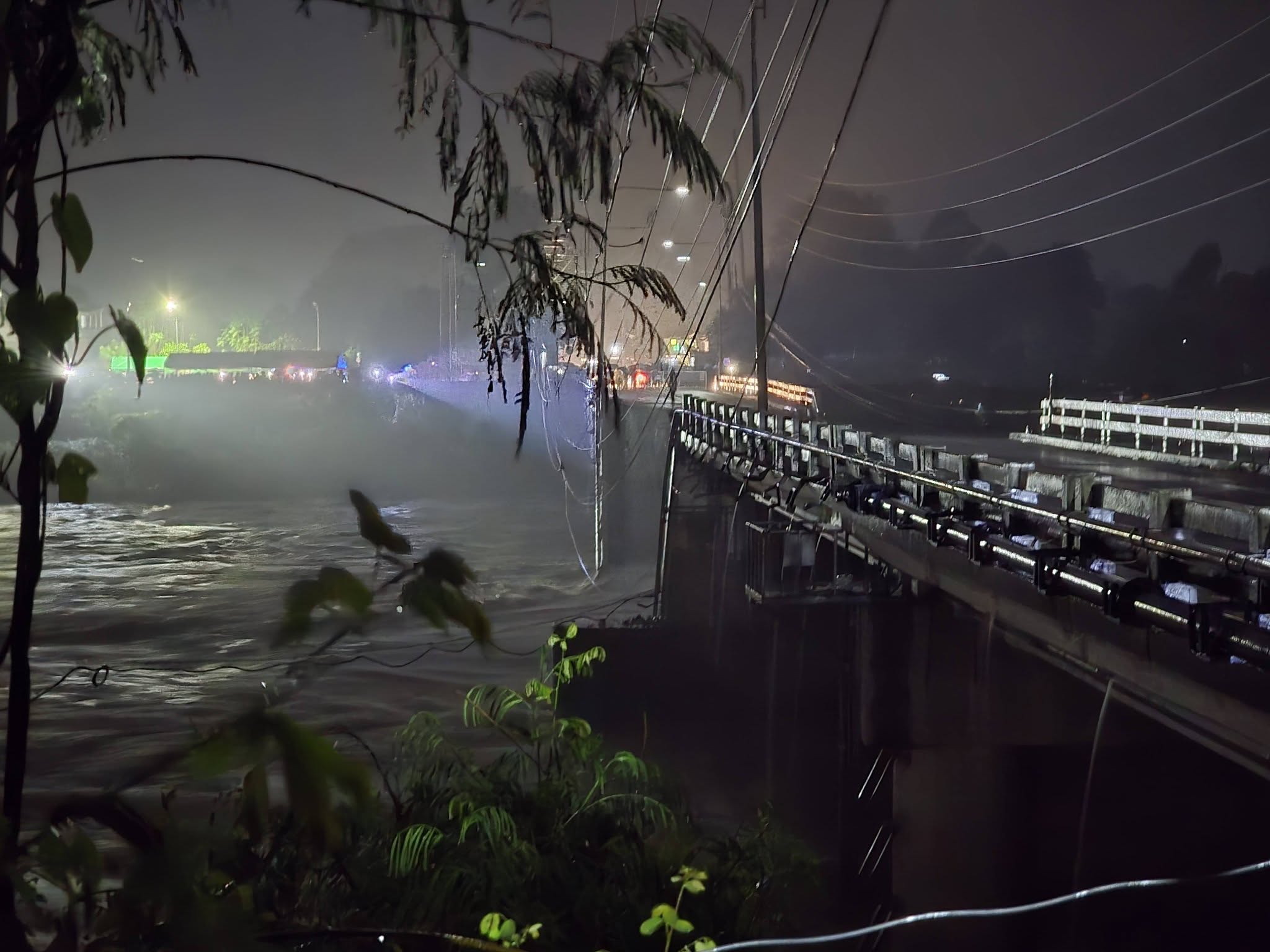 Collapsed section of Agana Bridge over the swollen Tarlac River at night